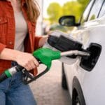 a girl refueling his car representing how can you avoid wasting fuel