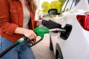 a girl refueling his car representing how can you avoid wasting fuel
